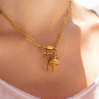 Woman wearing a paperclip carabiner gold necklace with charms