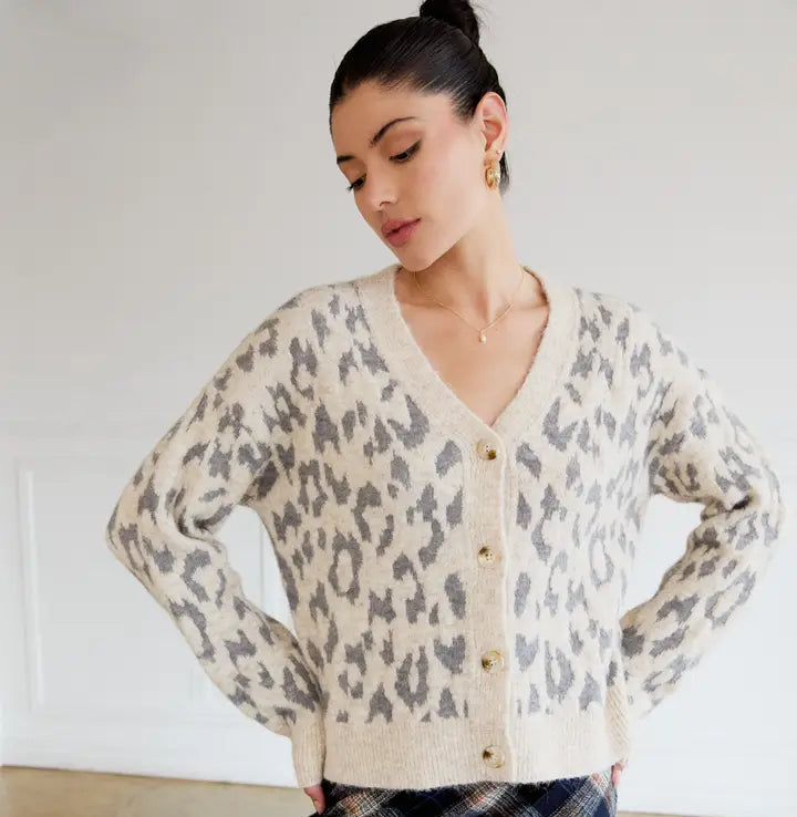 Woman wearing a leopard print cardigan against a white background