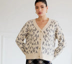 Woman wearing a leopard print cardigan indoors.