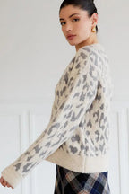 Woman wearing a leopartd print sweater against a white background