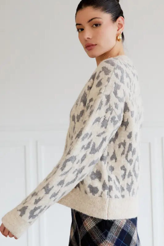 Woman wearing a leopartd print sweater against a white background