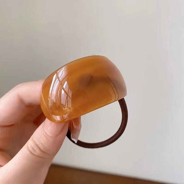 Brown marble resin hair tie on a white background