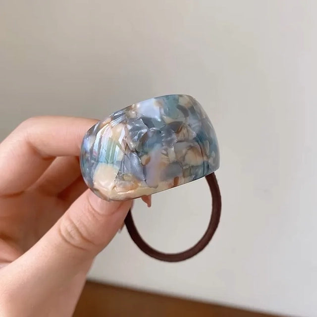 Blue marble resin hair tie on a white background