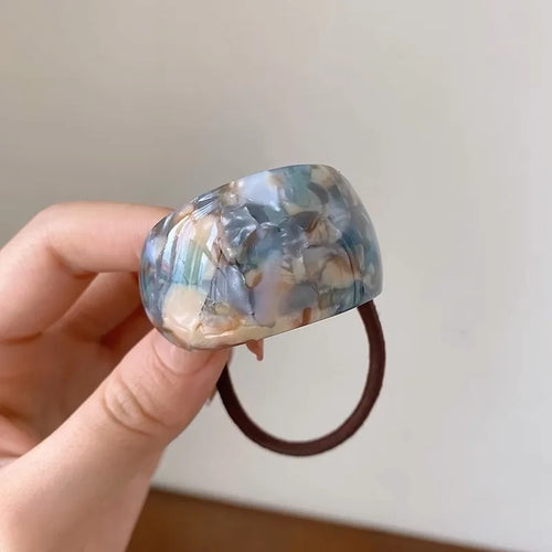 Blue marble resin hair tie on a white background