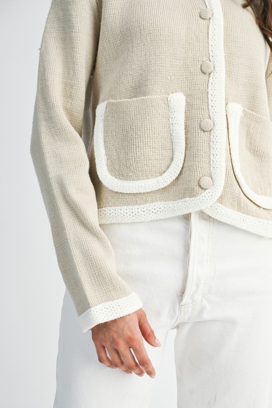 Lt. taupe and ivory cardigan  and white pants on a plain background