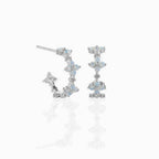Silver plated hoop earrings with blue stones in a flower design on a white background