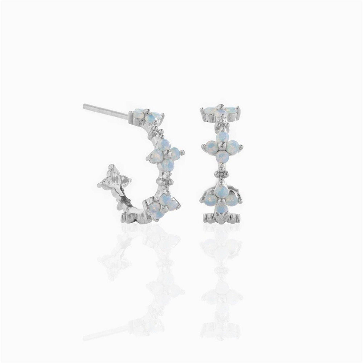 Silver plated hoop earrings with blue stones in a flower design on a white background