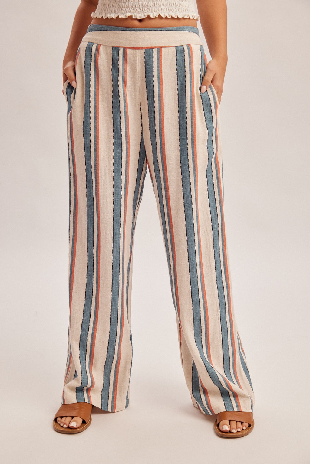 Woman wearing denim blue and red stripe linen feel pants on a gray background