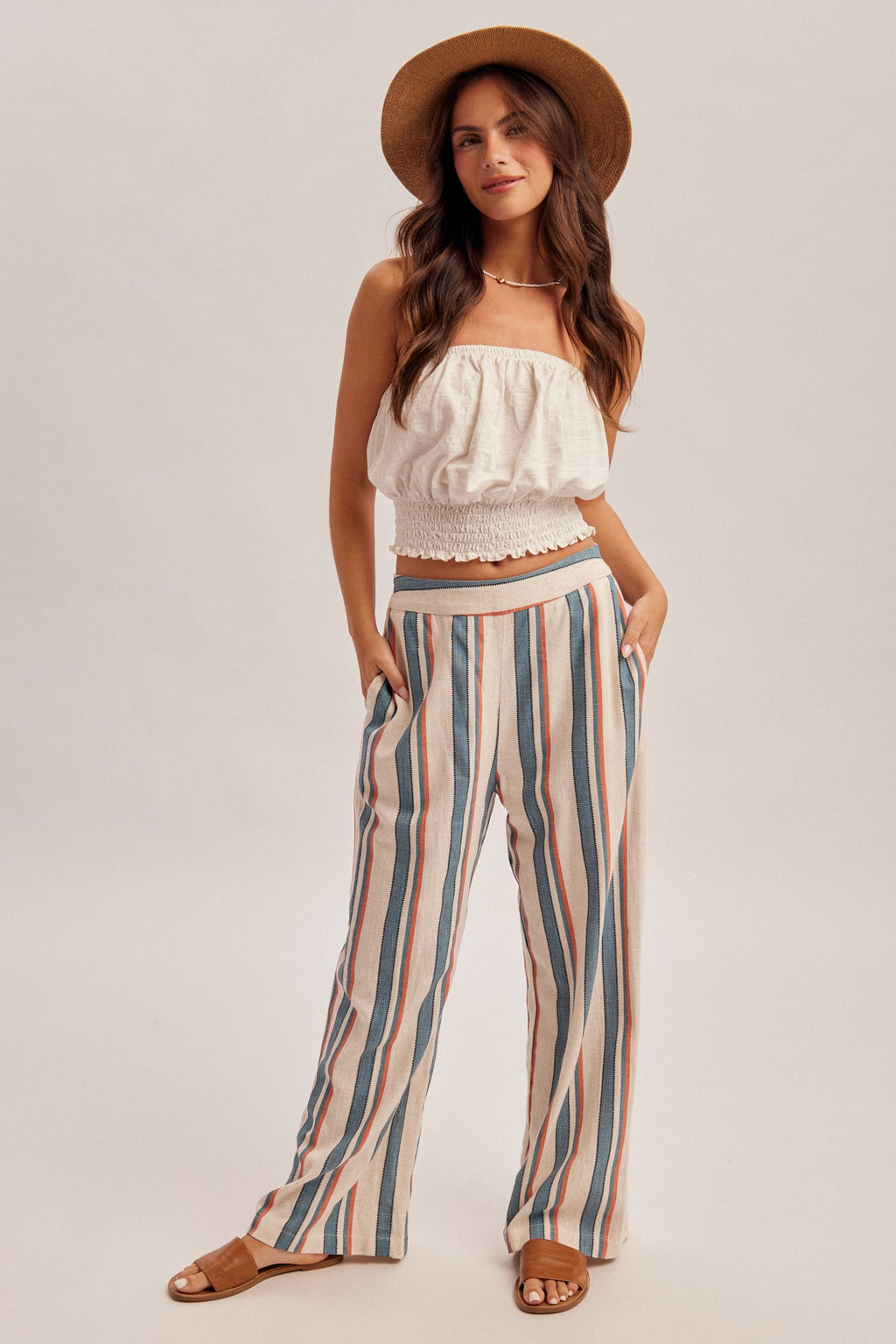 Woman wearing denim blue and red stripe linen feel pants on a gray background