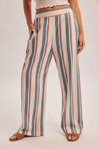 Woman wearing denim blue and red stripe linen feel pants on a gray background