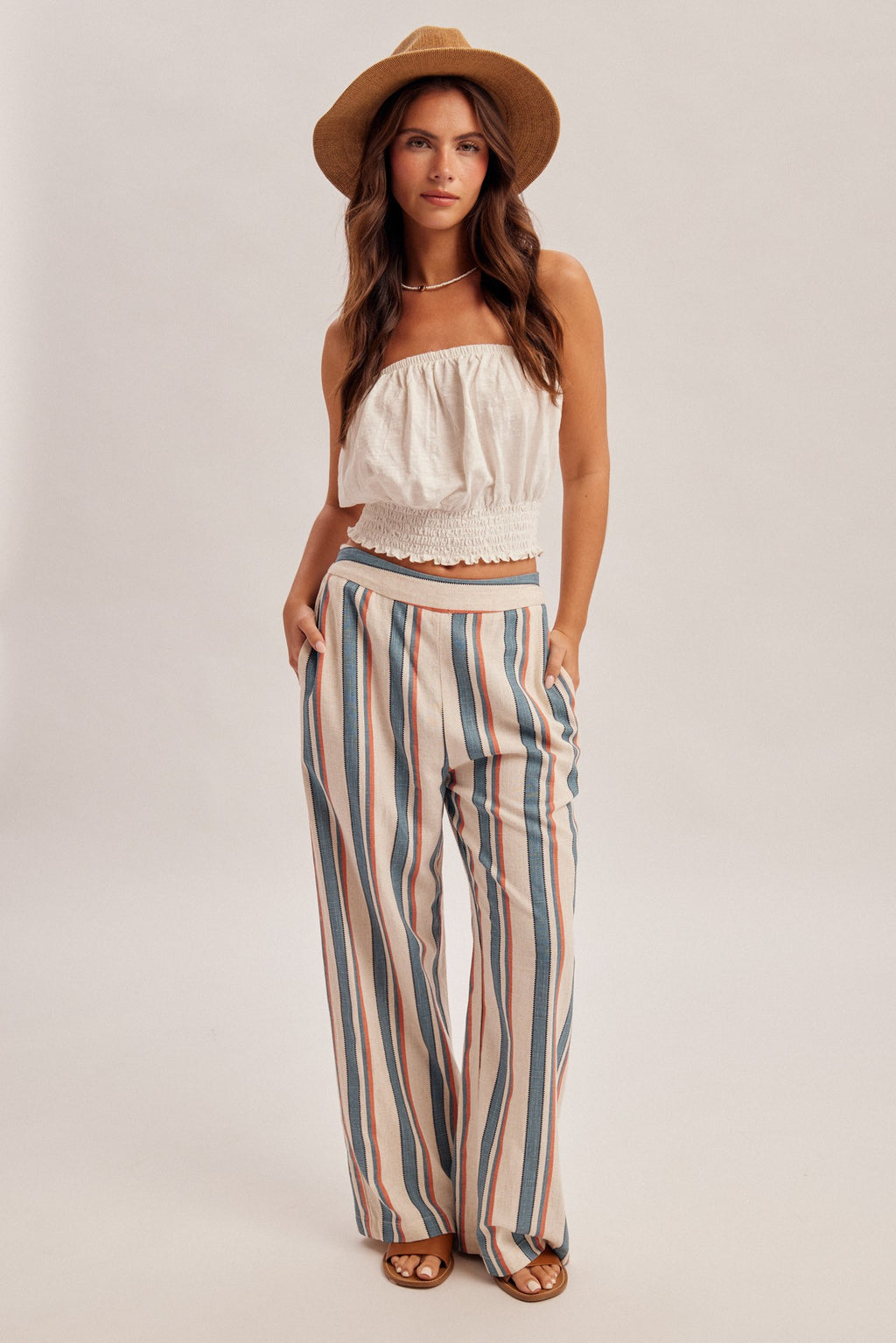 Woman wearing denim blue and red stripe linen feel pants on a gray background