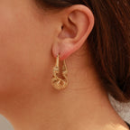 Woman wearing gold wired twisted hoop earrings