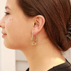 Woman wearing gold wired twisted hoop earrings