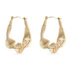 Gold wired twisted hoop earrings on a white background