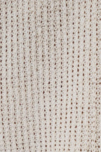 Close-up of a natural-colored boucle knit fabric with a textured openwork pattern.