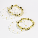 Two clear beaded bracelets with two gold tone bracelets