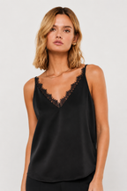 Woman wearing a black sleeveless tank top with lace details on a white background