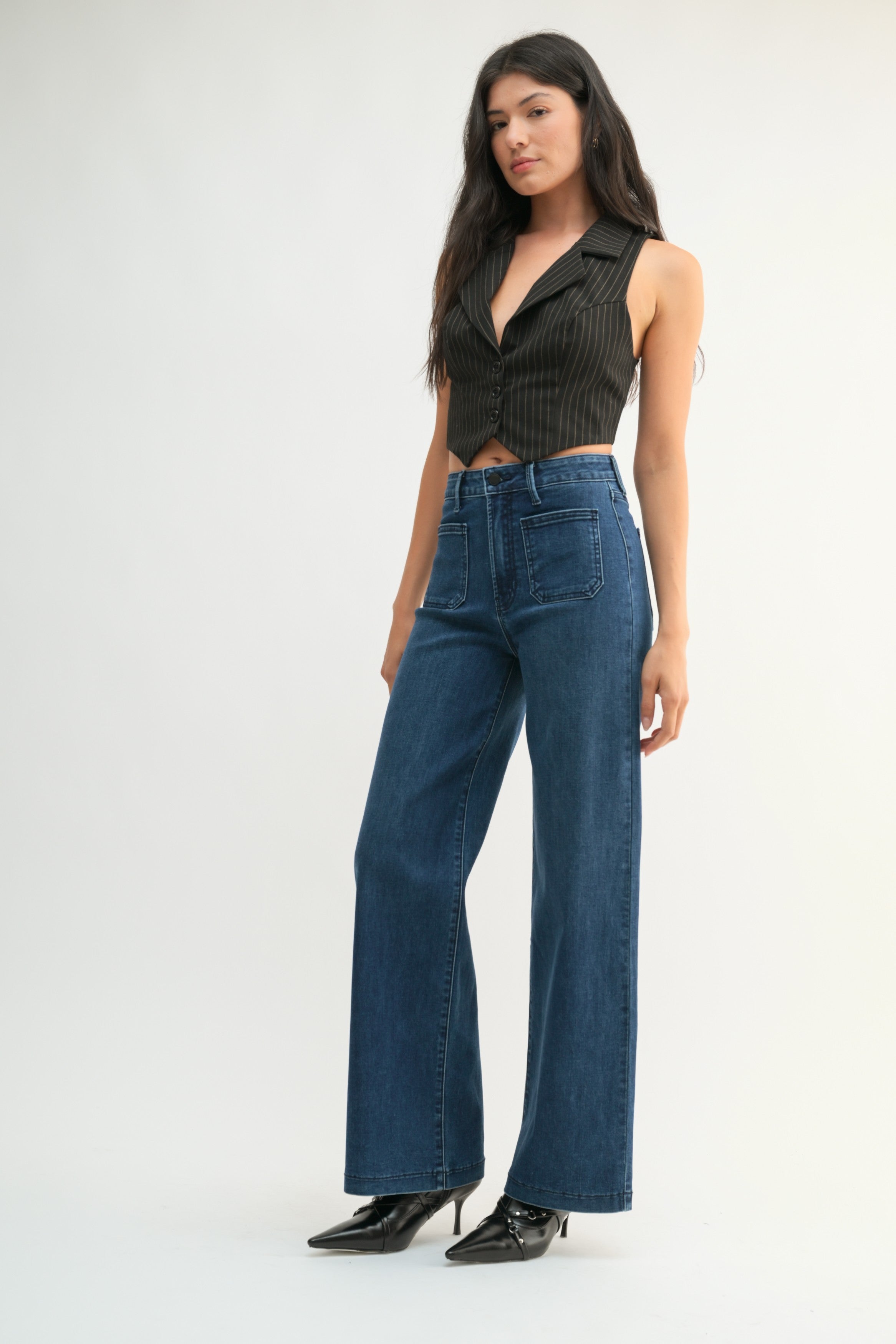 Woman wearing mini patch pocket jeans on a white background