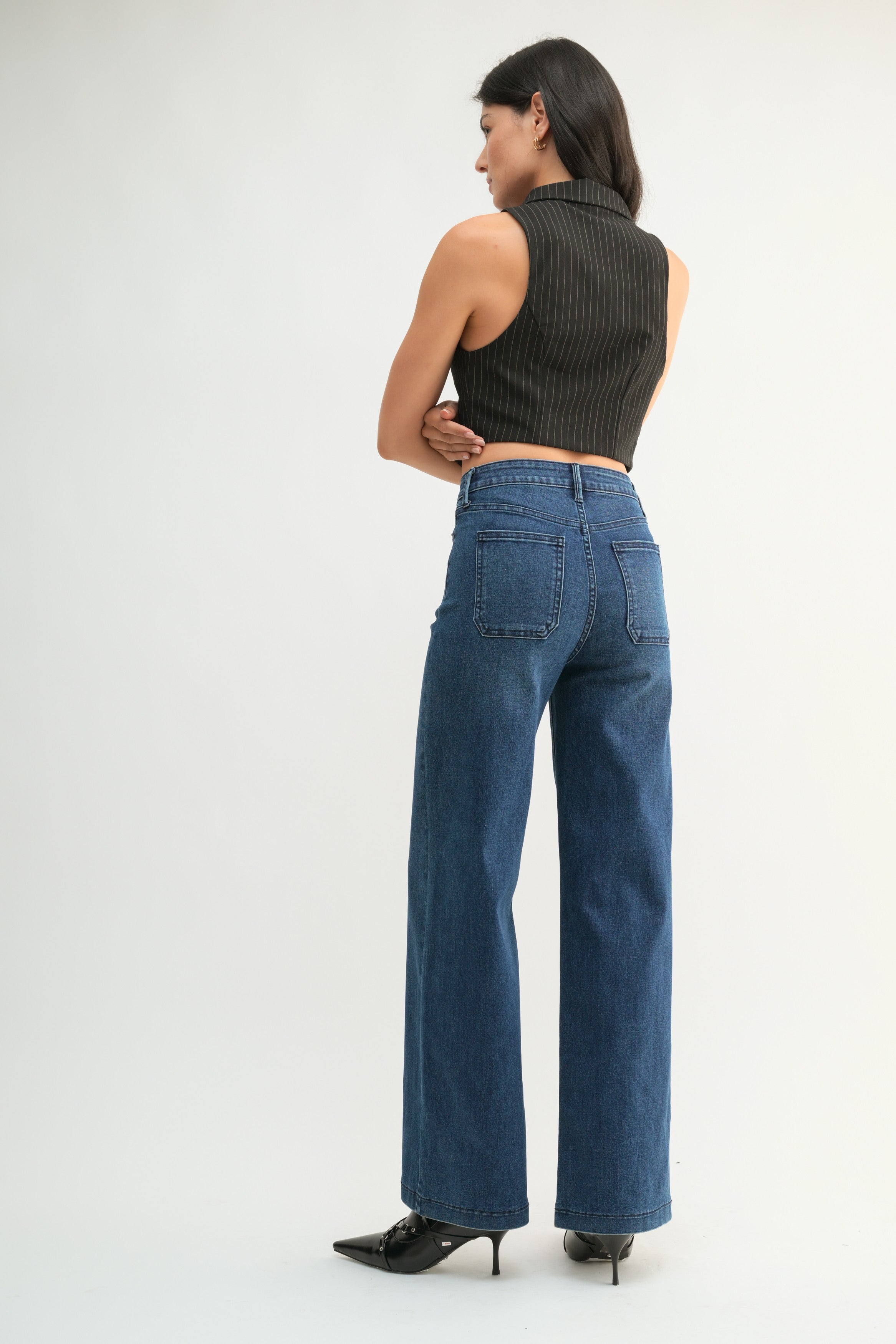 Woman wearing mini patch pocket jeans on a white background