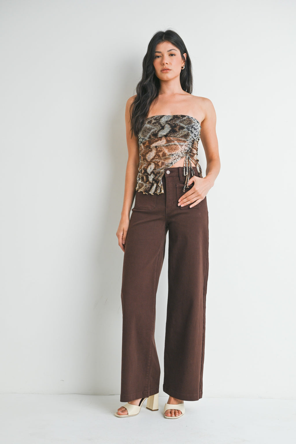 Woman wearing mini pach pocket dark brown jeans on a white background