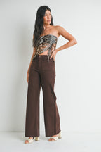 Woman wearing mini patch pocket dark brown jeans on a white background