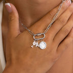 Woman wearing a silver paperclip carabiner necklace with charms