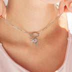 Woman wearing a silver paperclip carabiner necklace with charms