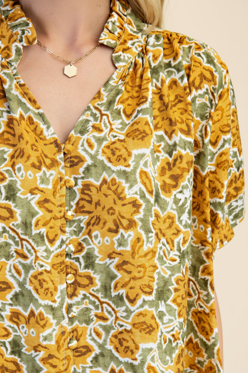 Close up of a floral mustard and green  pattern, set against a solid light green background.