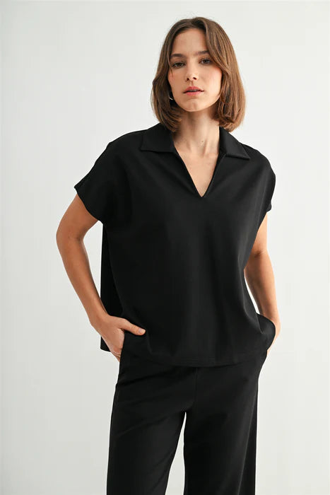 Woman wearing a black sleeveless shirt and pants on a white background