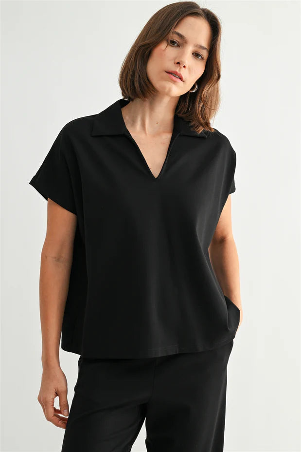 Woman wearing a black short sleeve shirt against a white background