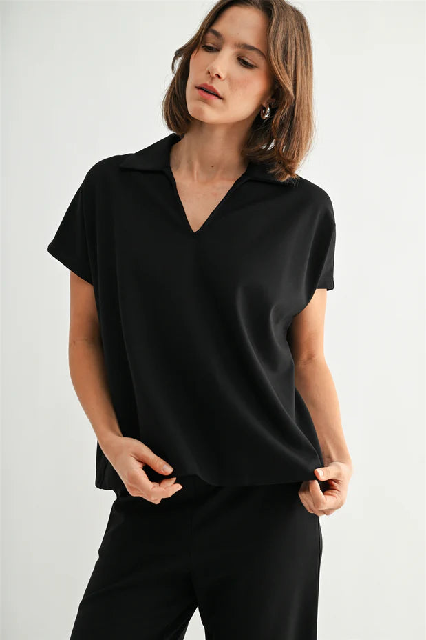 Woman wearing a black collar shirt against a white background