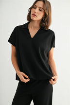 Woman wearing a black collar shirt against a white background