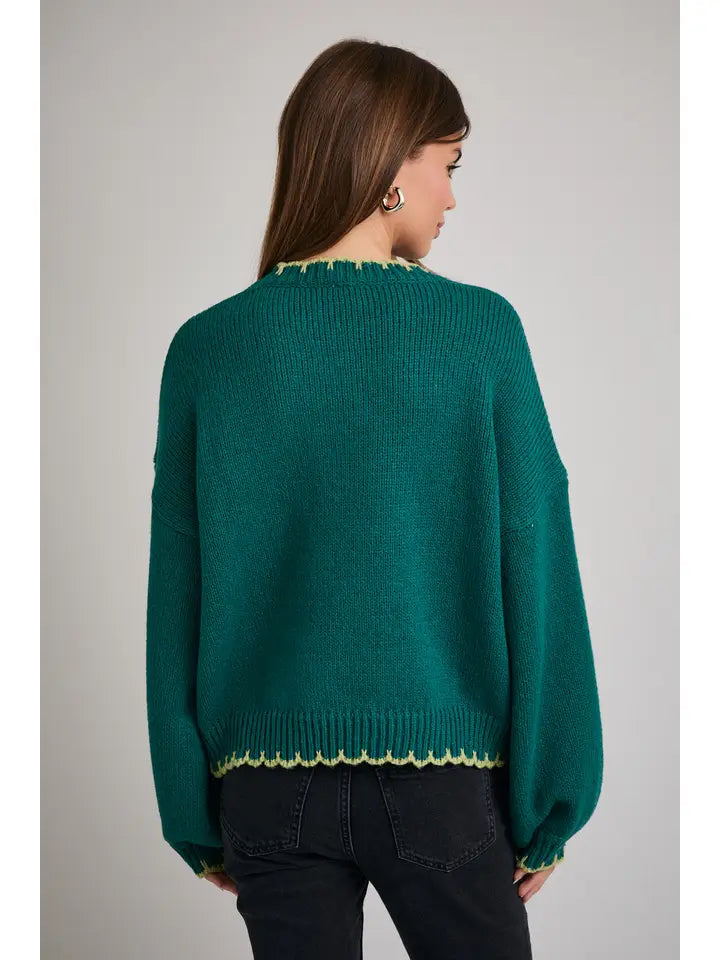 Back view of a woman wearing a green sweater with Christmas tree design on a gray background