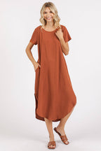 Woman wearing a copper midi dress with short sleeves on a white background