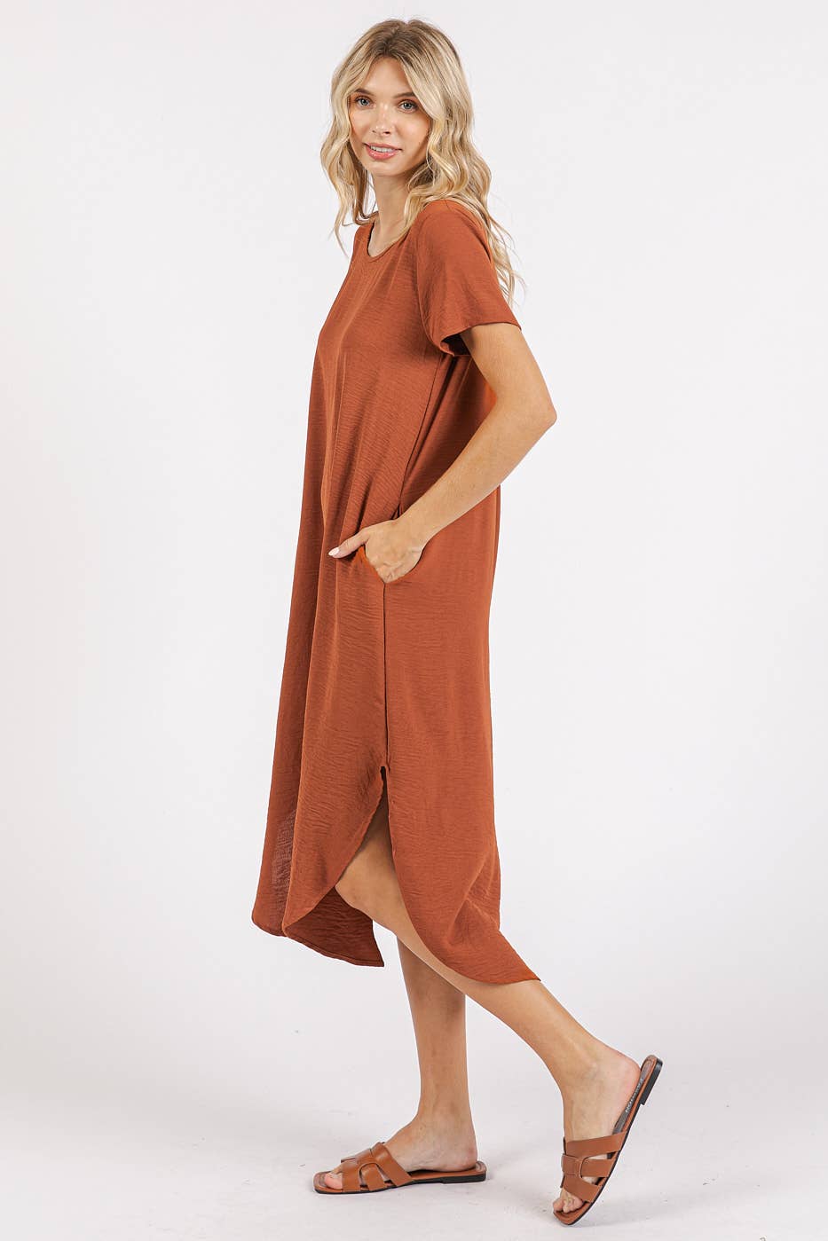 Woman wearing a copper midi dress with short sleeves on a white background