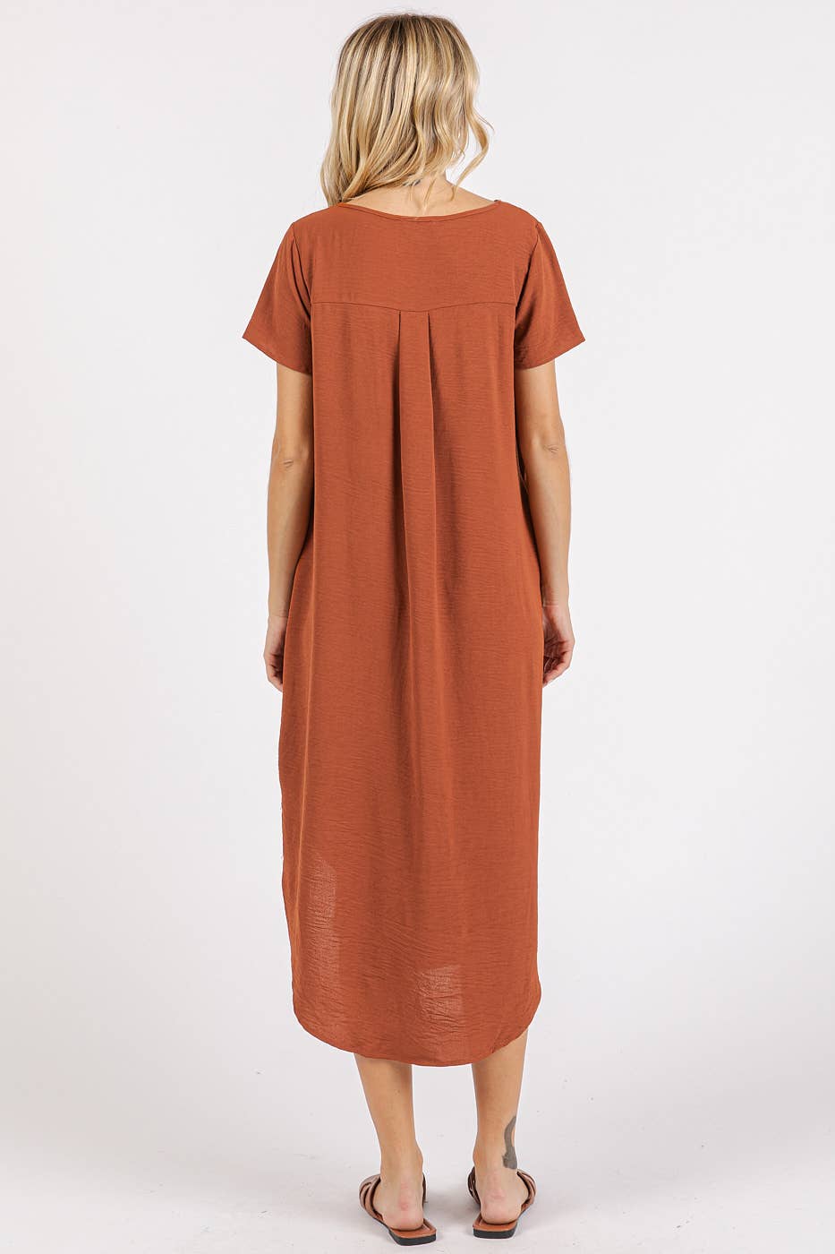 Back view of a woman wearing a copper midi dress with short sleeves on a white background