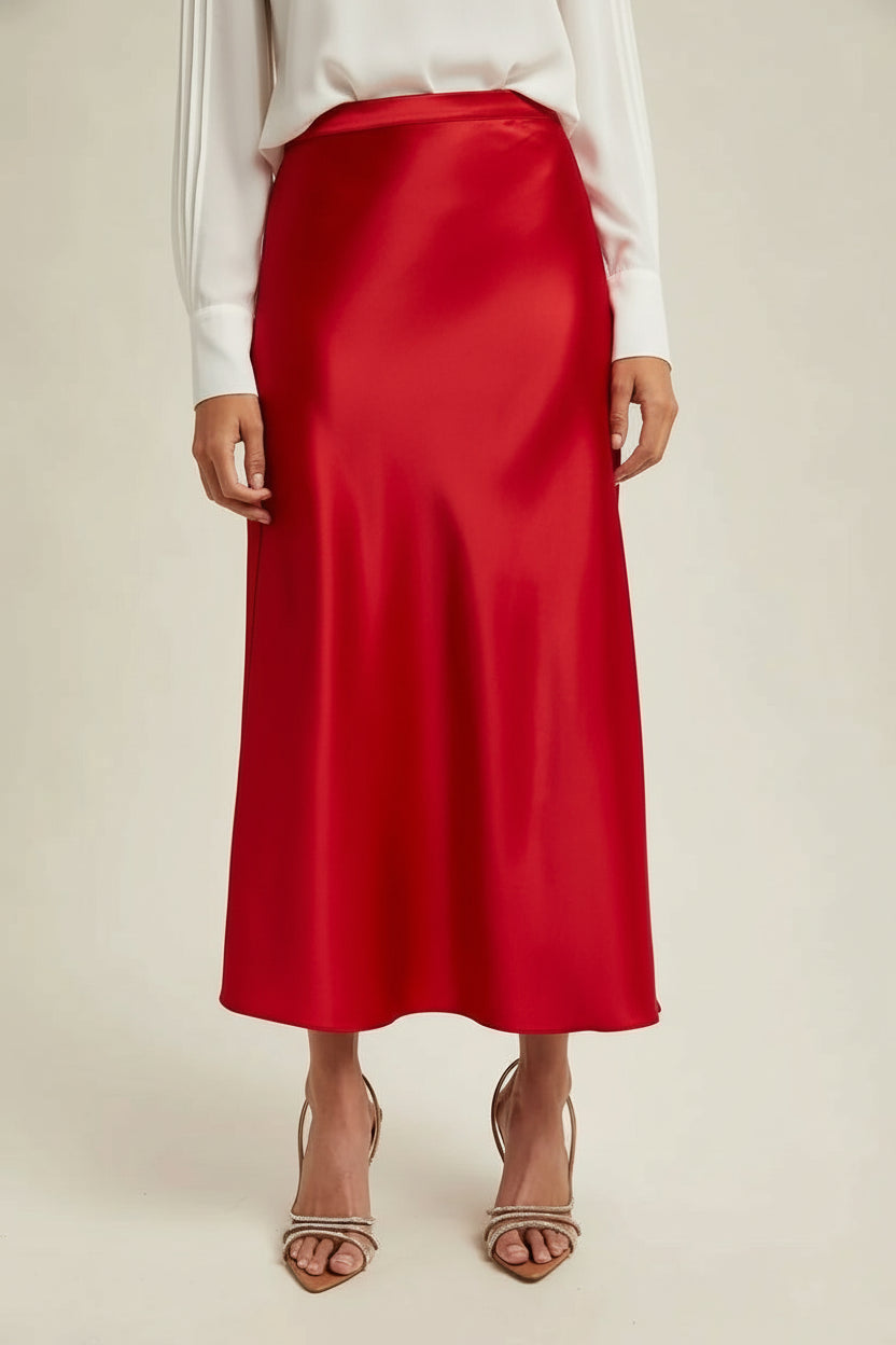 Woman wearingg a red satin skirt on a beige background