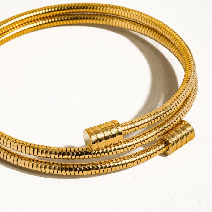 Gold round snake chain bracelet on a white background