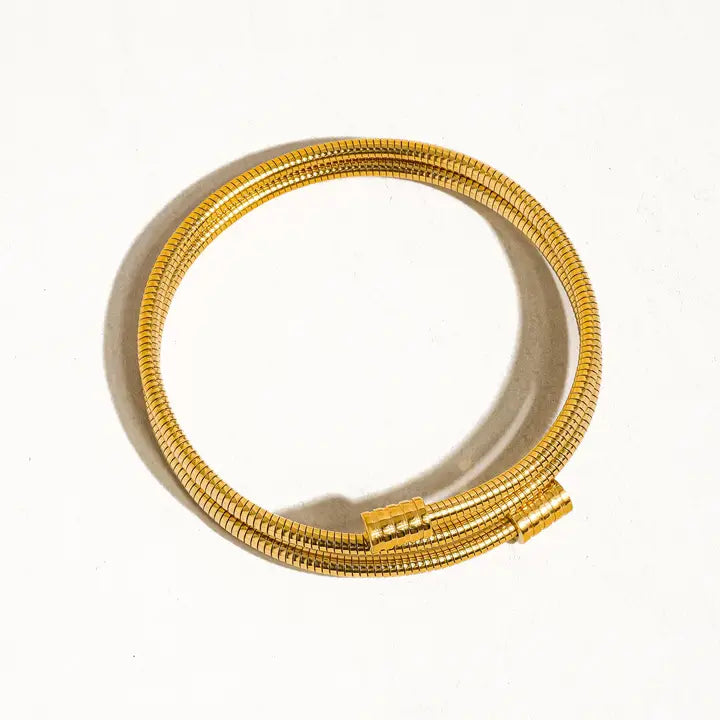 Gold round snake chain bracelet on a white background