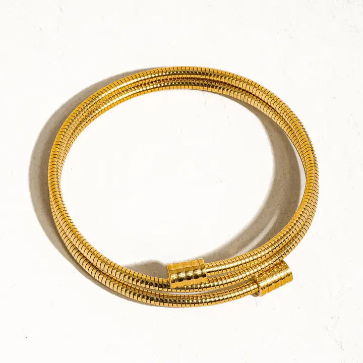 Gold round snake chain bracelet on a white background