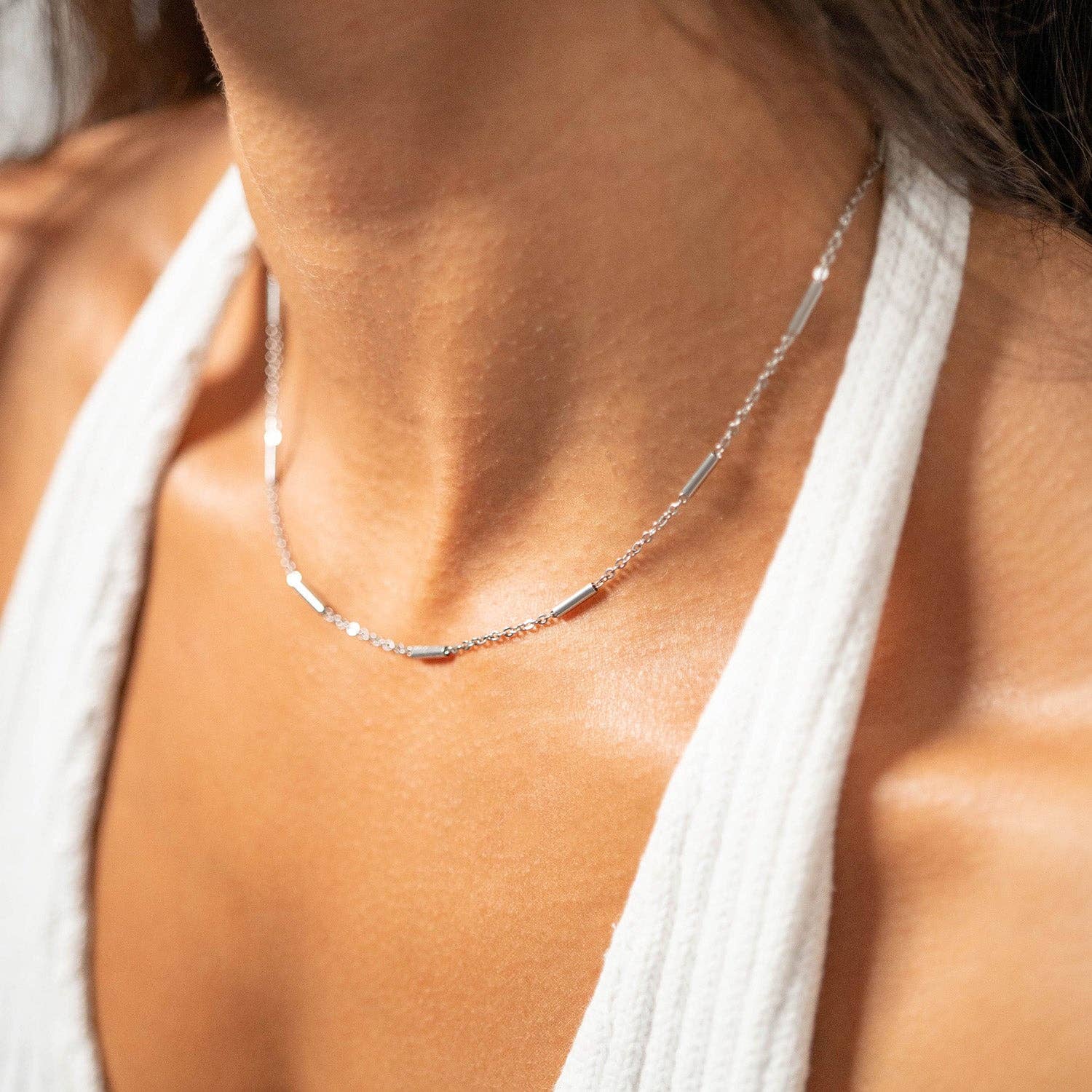 Woman wearing a bar and chain silver necklace