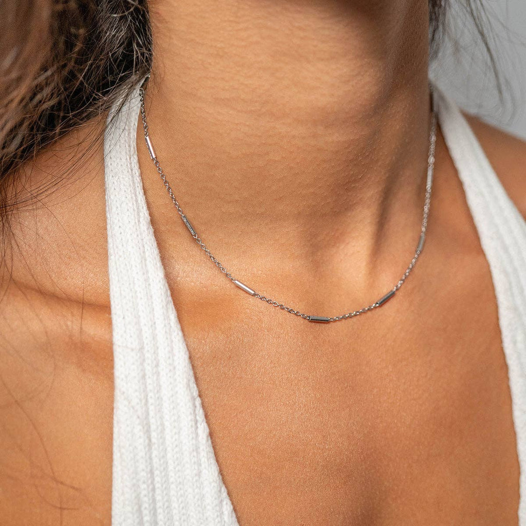 Woman wearing a bar and chain silver necklace