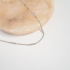 Silver bar and chain necklace on gray background