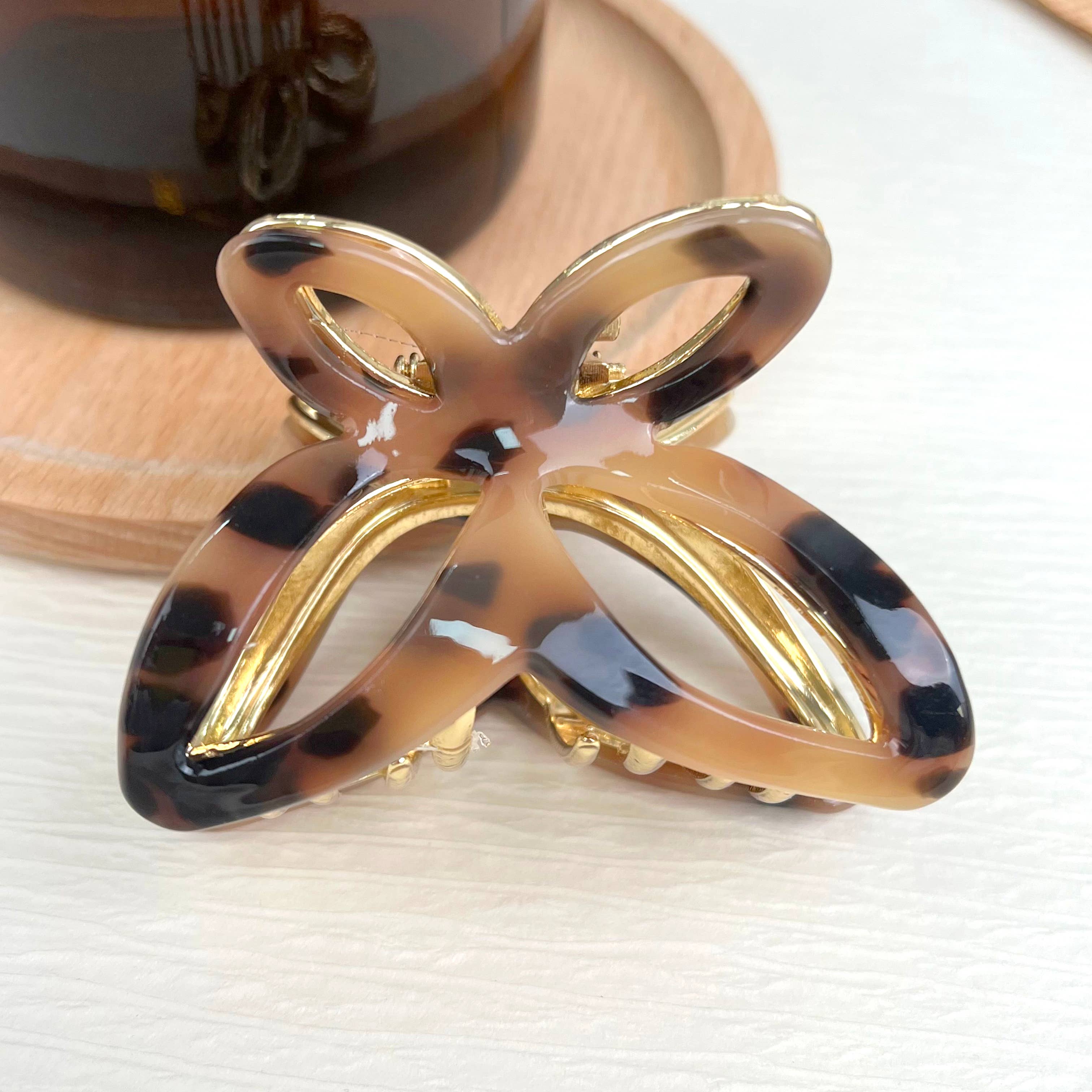 Women's Tortoise shell and gold hair clip on a white surface