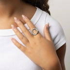 Woman wearing an oval silver plated stainless steel ring on white background