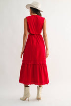 Woman wearing an embroidered cut-out red maxi dress on a white background