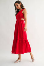 Woman wearing an embroidered cut-out red maxi dress on a white background