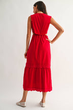 Back view of a woman wearing an embroidered cut-out red maxi dress on a white background