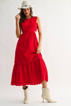 Woman wearing an embroidered cut-out red maxi dress on a white background
