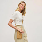 Woman with a tan cell phone wallet crossbody against a white background